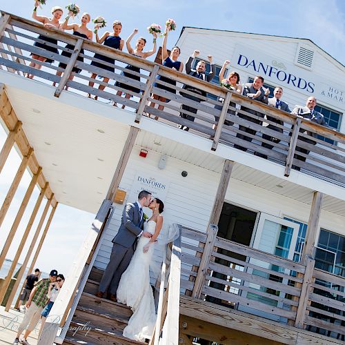 A bride and groom kiss on the steps of a building called 