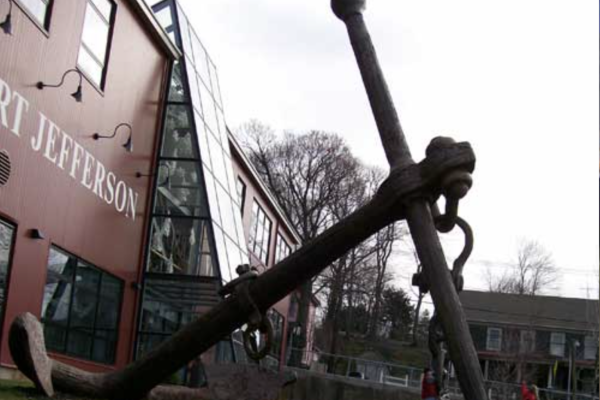 The image shows a large anchor displayed outside a building with 