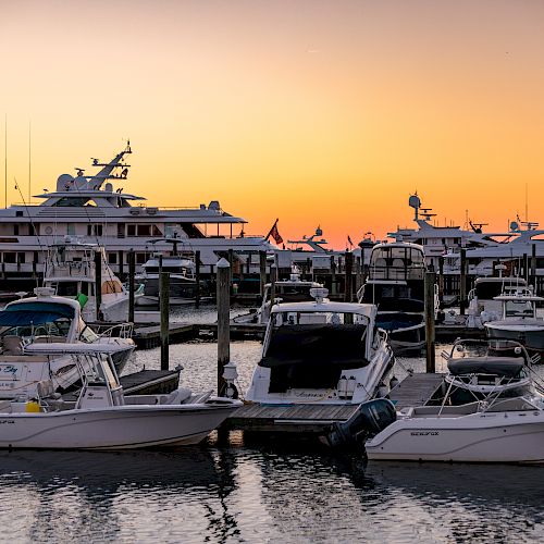 This image shows a marina with several boats docked at sunset, creating a serene and picturesque scene.